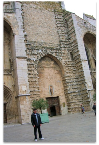 John Barrow standing in front of the Basilica of St Mary Magdalene; the unfinished front is visible