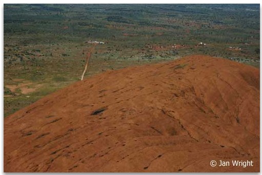 Photo taken flying low over Ayers Rock - Uluru showing roads to camps in the background